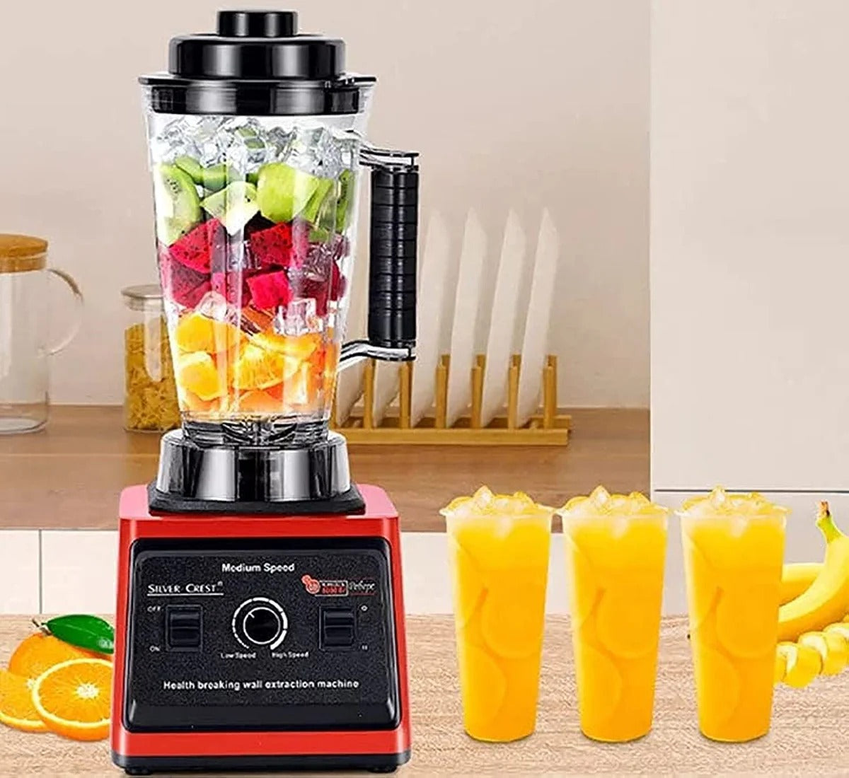 Blender with ingredients and smoothies on a kitchen counter