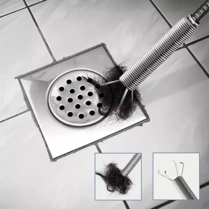 Drain with hair being cleared by a tool on a tiled floor
