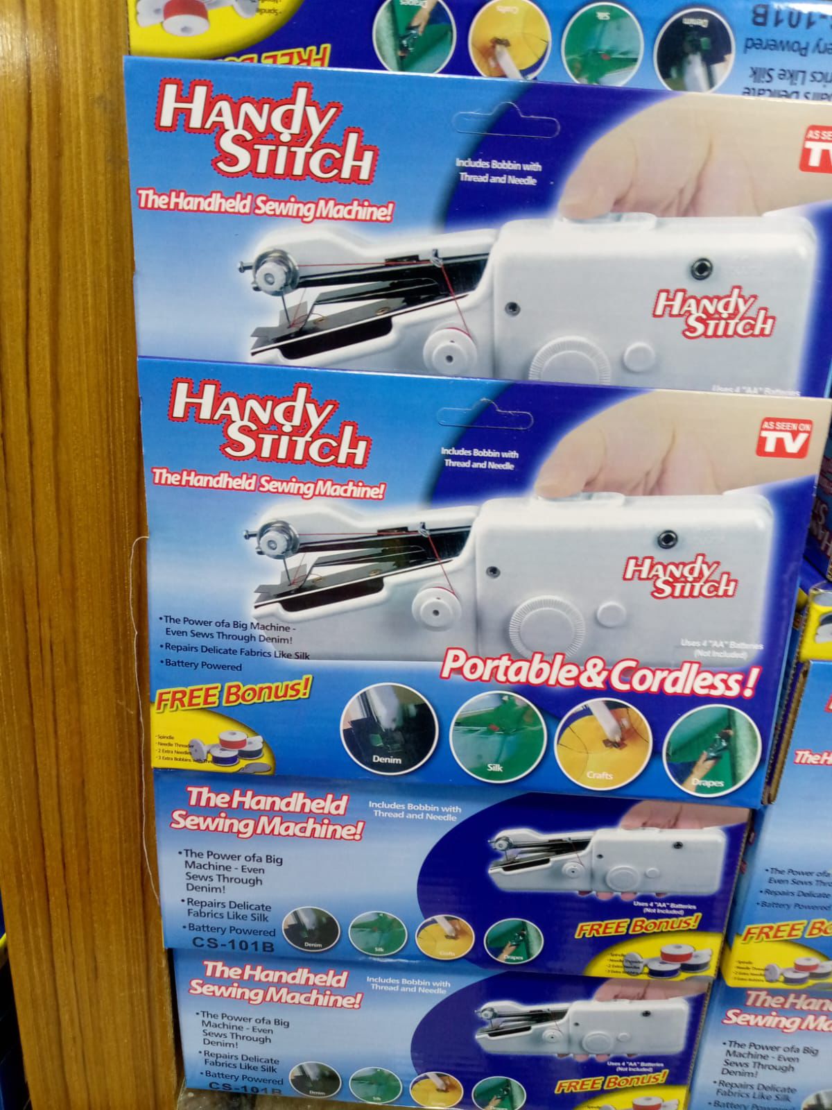 Handy Stitch handheld sewing machine packaging on a wooden surface