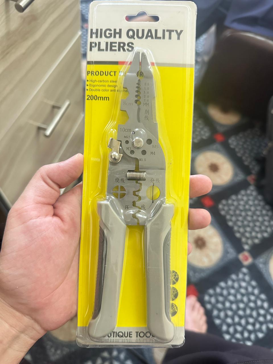 High-quality pliers in packaging held by a hand with a blurred background