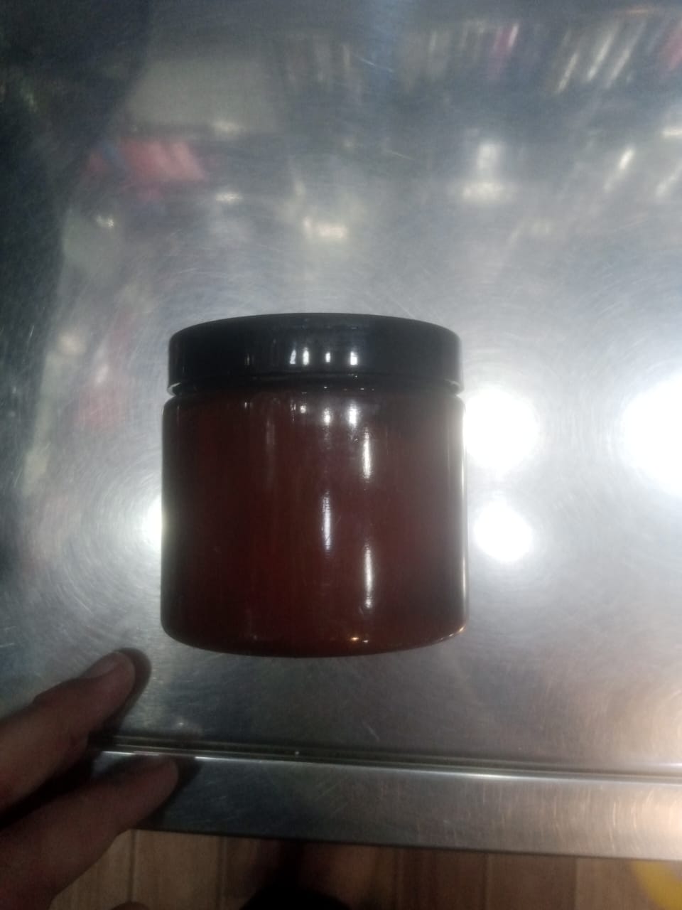 Jar of red paste on a metallic surface