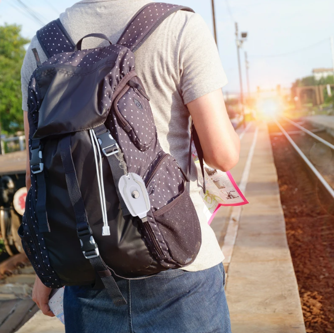 Person with a backpack on a train platform with sunlight in the background