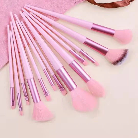 Set of pink makeup brushes on a light background