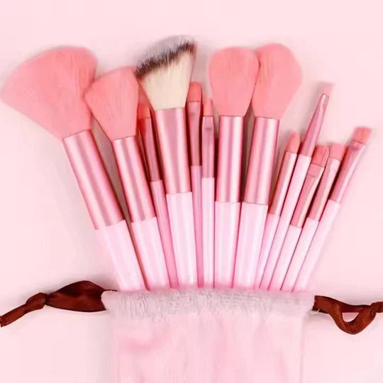 Set of pink makeup brushes with a carrying case on a light pink background