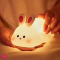 Cute rabbit-shaped night light being held by a hand with a warm glow.