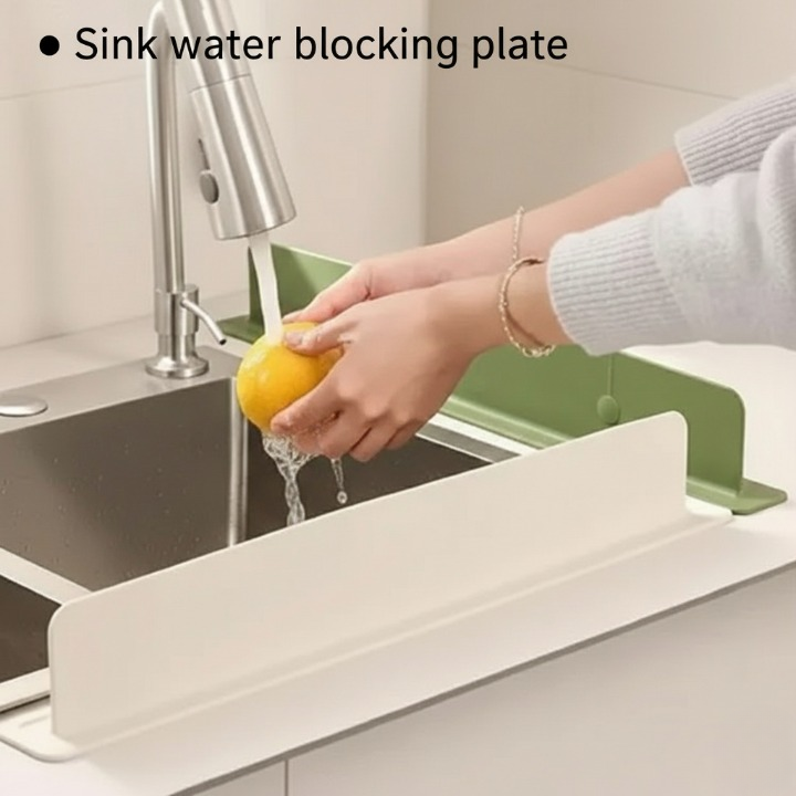 Person washing a lemon under running water with a sink water blocking plate in the foreground.