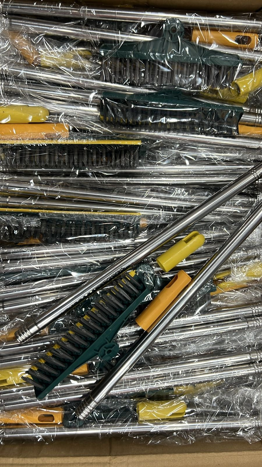 Stack of car brushes with plastic wrap on a wooden surface