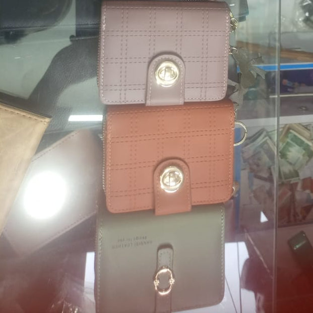 Three wallets stacked on a reflective surface with blurred background