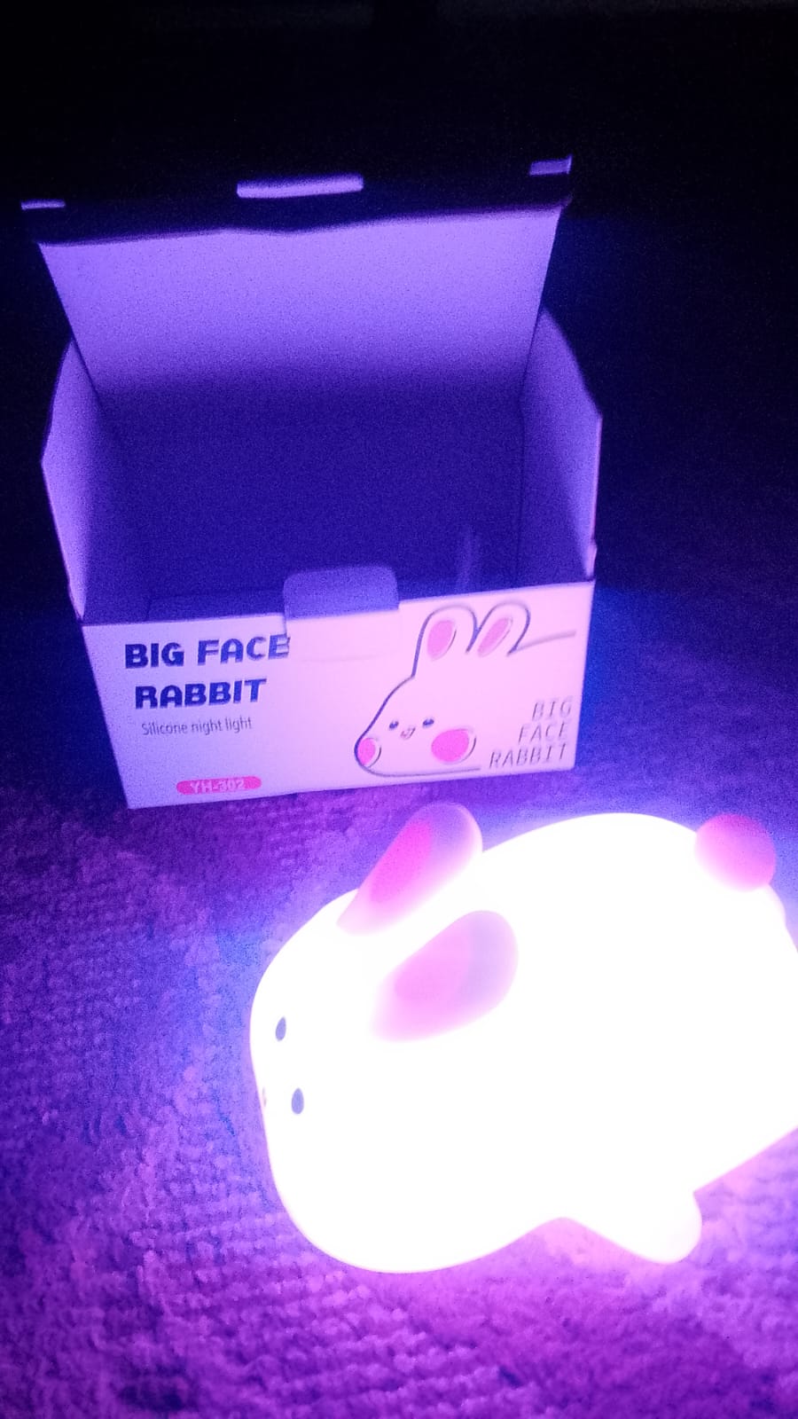 rabbit-shaped night light with packaging on a dark background